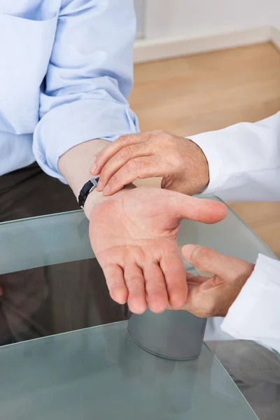 Doctor Taking Senior Man's Pulse — Stock Photo, Image