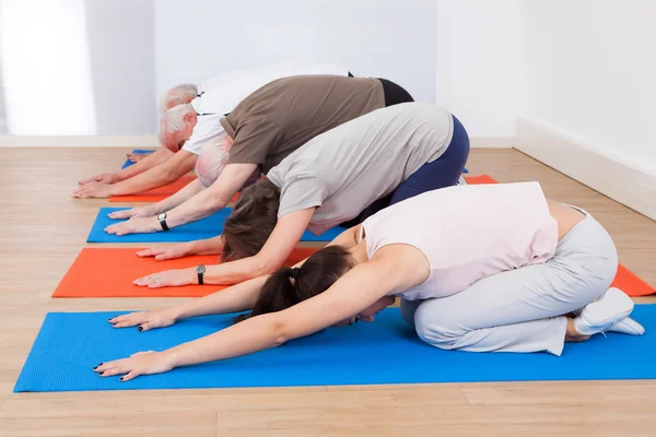 Pessoas realizando Yoga no ginásio — Fotografia de Stock