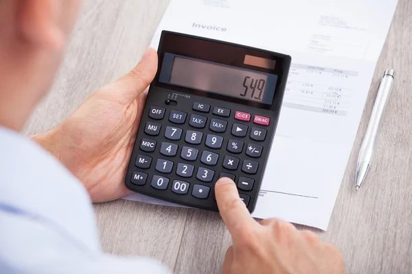 Businessman Calculating Invoice At Desk — Stock Photo, Image