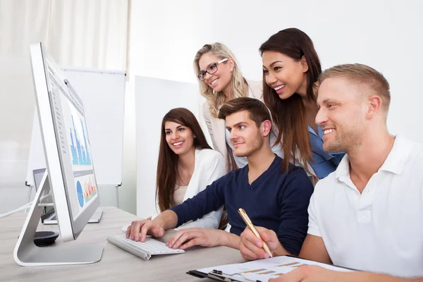 Smiling Businesspeople Using Desktop PC