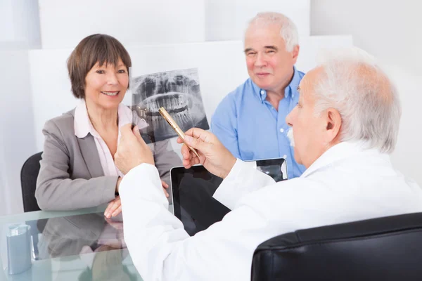 Dentista explicando rayos X a pareja mayor —  Fotos de Stock