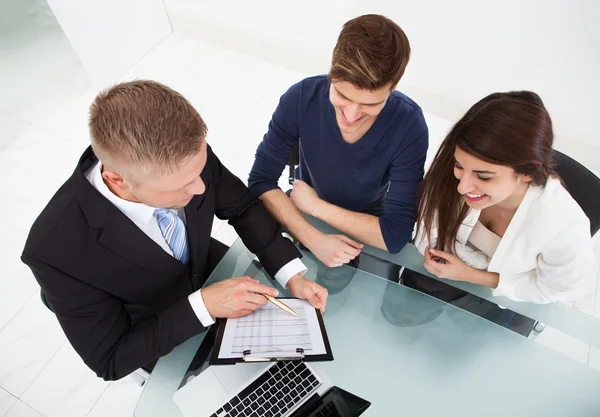 Asesor Financiero Explicando Plan de Inversión a Pareja Imagen de stock