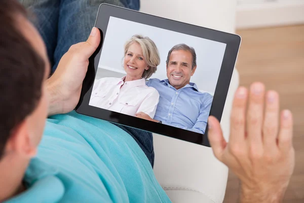 Man Having Video Chat With Parents On Digital Tablet — Stock Photo, Image