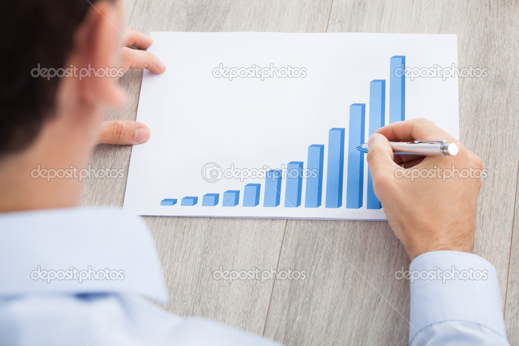 Businessman Analyzing Graph At Desk