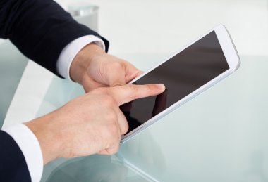 Masa başında dijital tablet kullanarak iş adamı