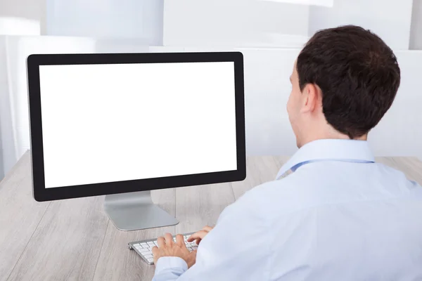 Zakenman met behulp van desktop-pc aan balie — Stockfoto