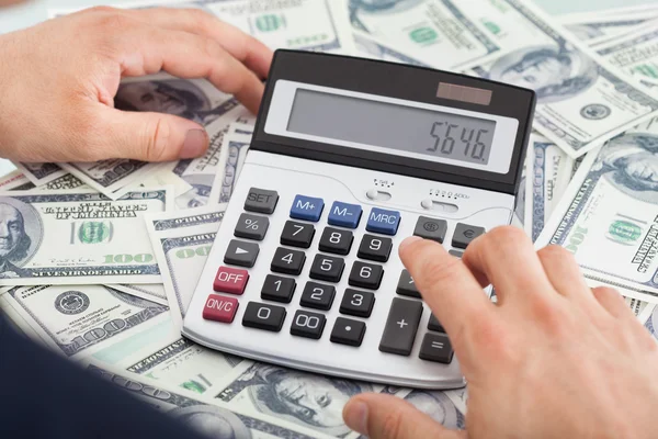 Businessman Calculating Money In Office — Stock Photo, Image