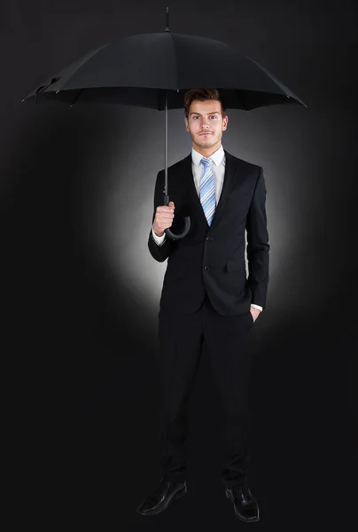 Retrato del hombre de negocios que sostiene el paraguas — Foto de Stock