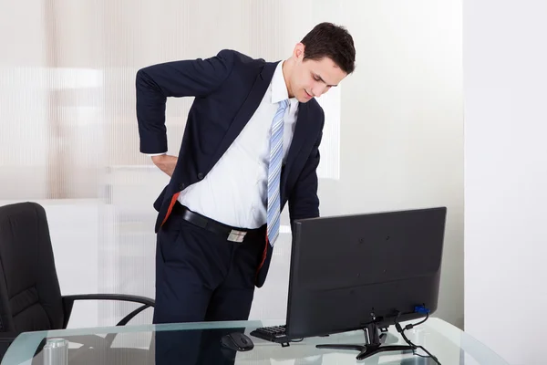 Empresário sofrendo de dor nas costas no cargo — Fotografia de Stock