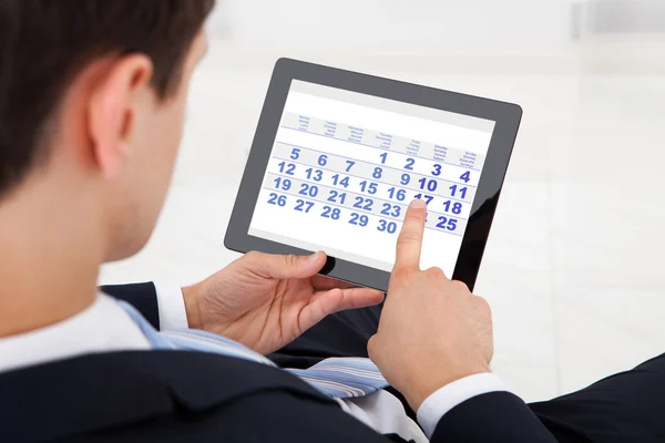 Homme d'affaires utilisant le calendrier sur la tablette numérique dans le bureau — Photo