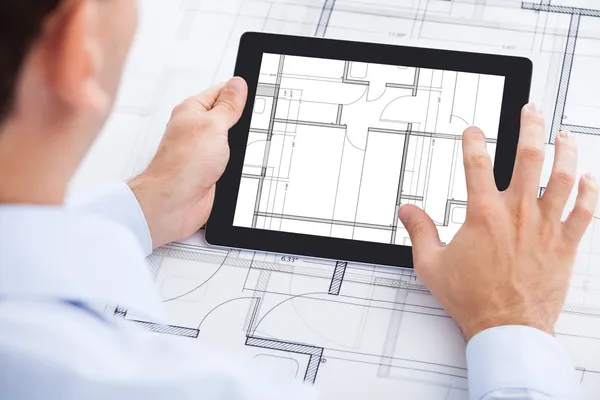 Architect analyseren blauwdruk op digitale Tablet PC — Stockfoto