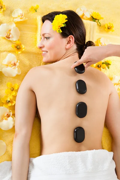 Frau erhält Hot-Stone-Therapie im Wellnessbereich — Stockfoto