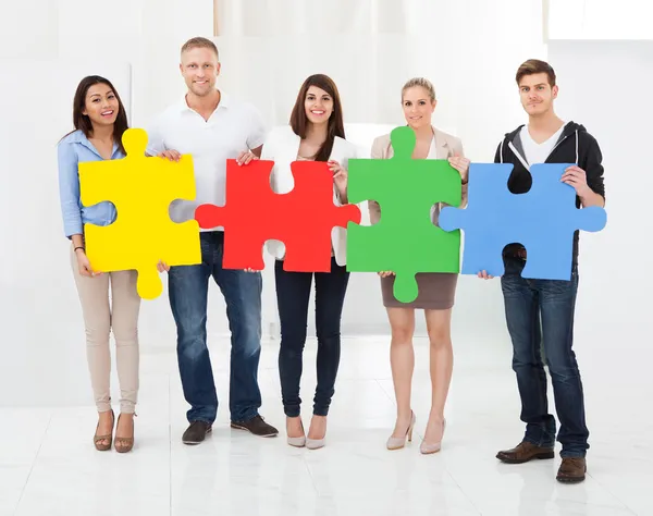 Confident Businesspeople Joining Puzzle Pieces — Stock Photo, Image