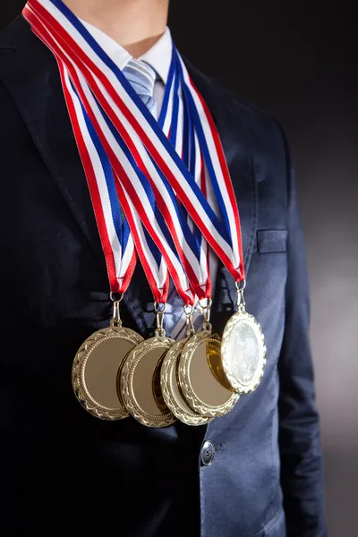 Empresário vestindo medalhas de ouro — Fotografia de Stock