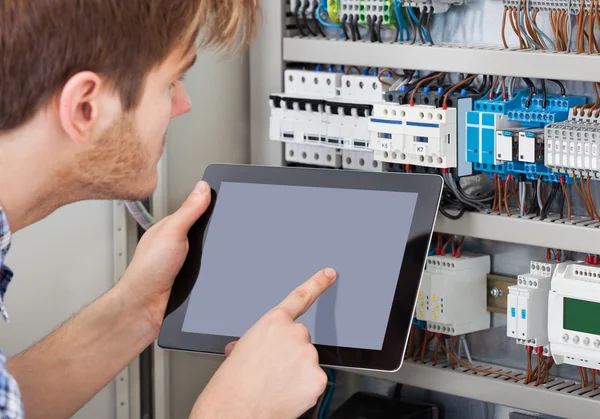 Technicien examinant Fusebox en utilisant la tablette — Photo