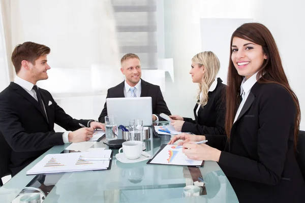 Mujer de negocios sentada con colegas en la reunión — Foto de Stock