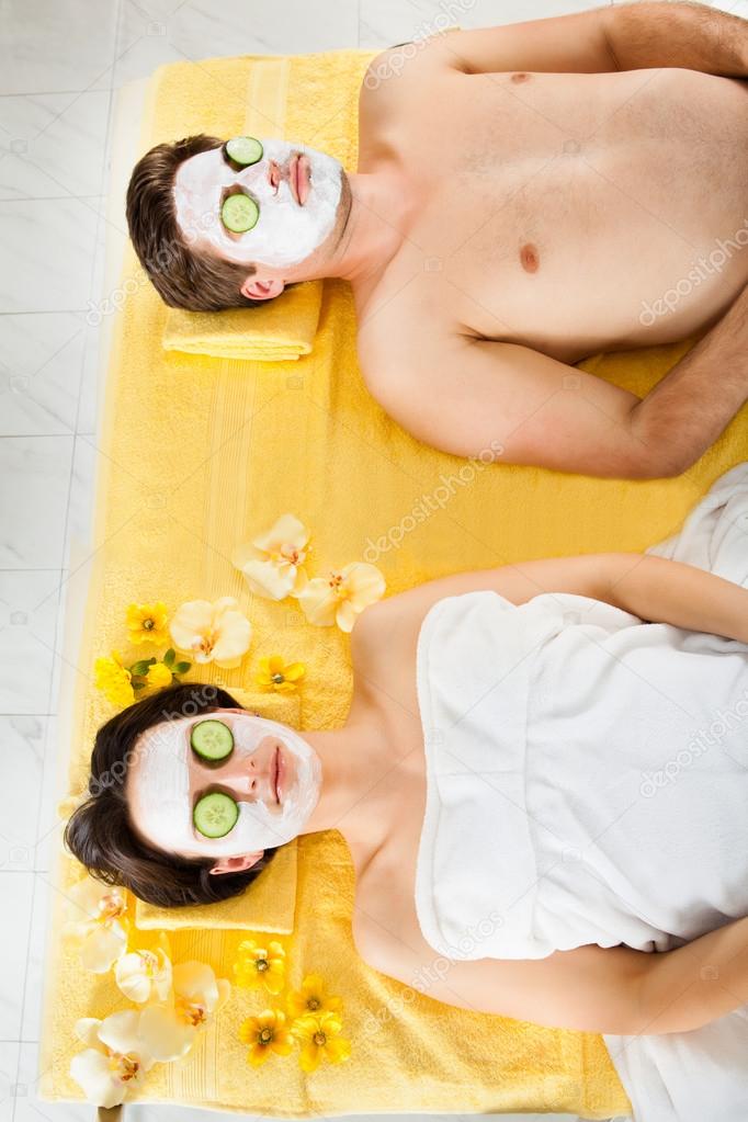 Couple With Face Mask Relaxing In Beauty Spa
