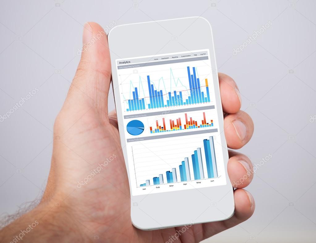 Hand Holding Mobile Phone With Financial Charts
