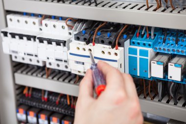 Electrician Examining Fusebox With Screwdriver clipart