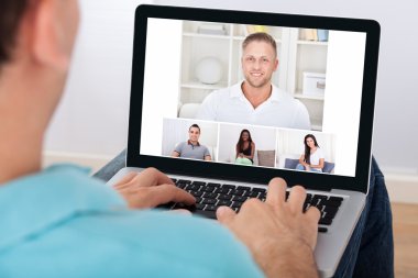 Arkadaş grubu video konferans olan adam