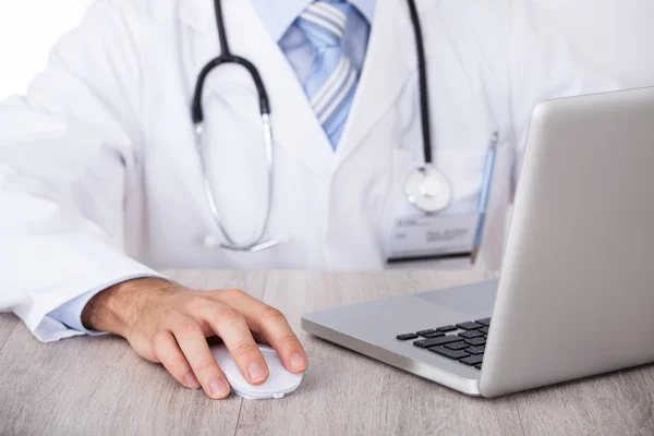 Brzuch lekarz za pomocą laptopa i myszy na biurku — Zdjęcie stockowe