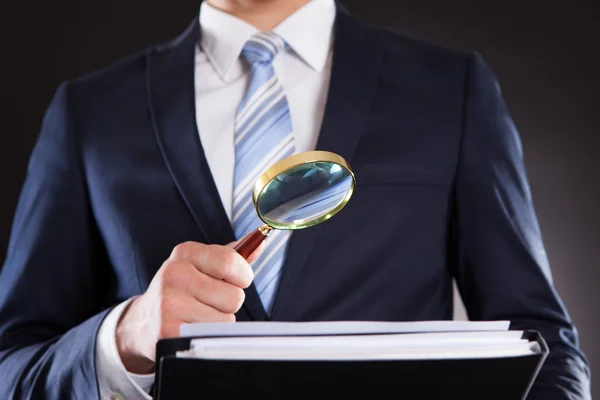 Businessman Examining Documents With Magnifying Glass — Stock Photo, Image