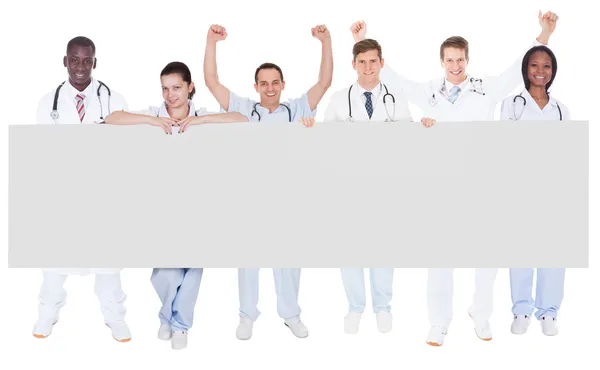 Des médecins confiants tenant un panneau d'affichage vierge — Photo