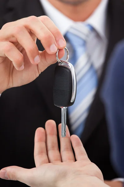 Agente que da llave del coche al hombre — Foto de Stock