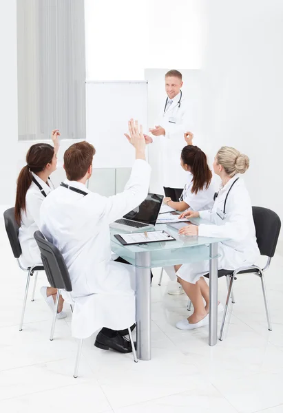 Médicos respondiendo a su colega en la reunión — Foto de Stock