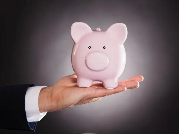 Homem de negócios segurando piggybank — Fotografia de Stock