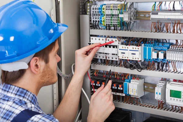 Technicus onderzoekende fusebox — Stockfoto