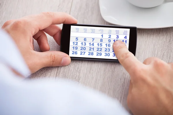 Zakenman met mobiele telefoon kalender — Stockfoto