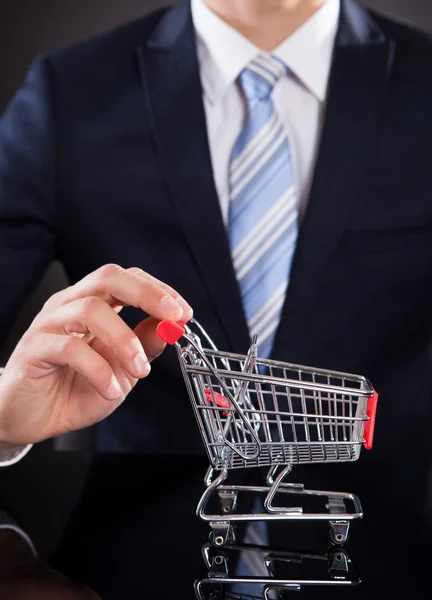 Affärsman med shopping cart modell — Stockfoto