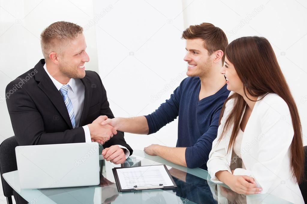 Financial Advisor Shaking Hand With Couple