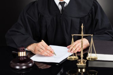 Judge Writing On Paper At Desk clipart