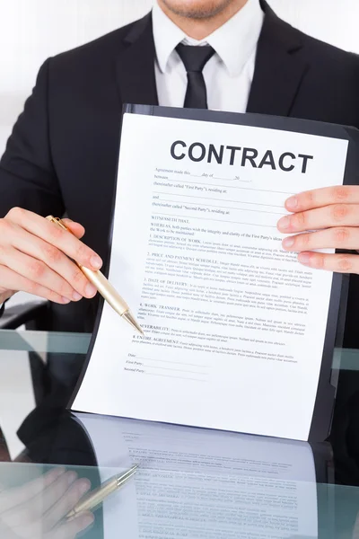 Empresario mostrando papel de contrato en el escritorio de la oficina — Foto de Stock