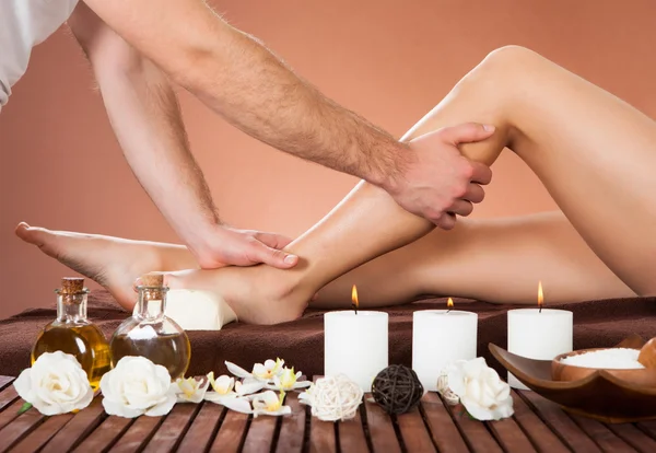 Terapeuta masajeando pierna del cliente en spa de belleza —  Fotos de Stock