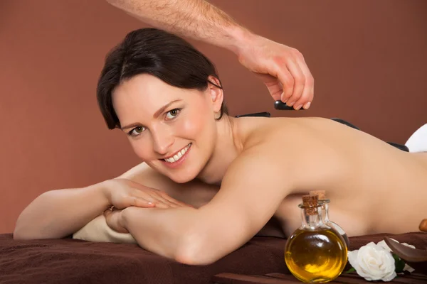 Frau erhält Hot-Stone-Therapie im Wellnessbereich — Stockfoto