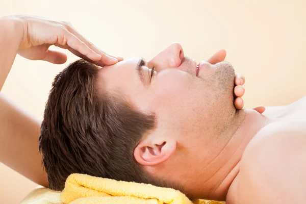 Homem recebendo massagem na testa no spa — Fotografia de Stock