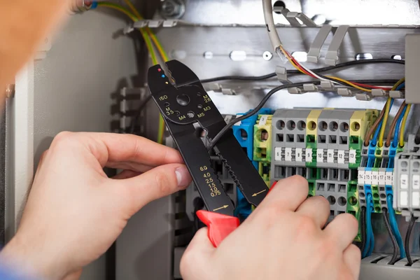 Technician Cutting Cable With Fusebox In Background — Stock Photo, Image