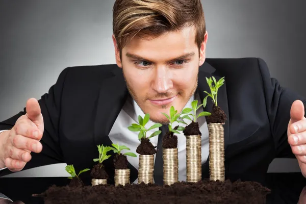 Businessman Protecting Coins In Saplings — Stock Photo, Image