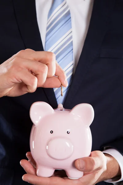 Businessman Inserting Coin In Piggybank — Stock Photo, Image