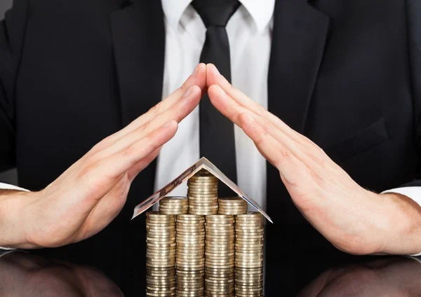 Zakenman afscherming huis gemaakt geld op het Bureau — Stockfoto