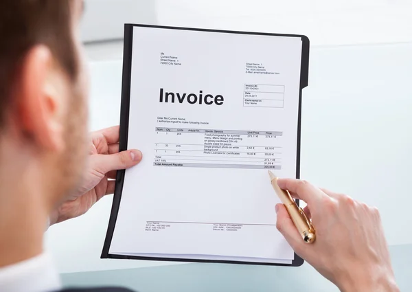 Businessman Analyzing Invoice At Office Desk — Stock Photo, Image