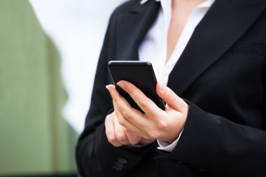 İş kadını akıllı telefon kullanıyor.