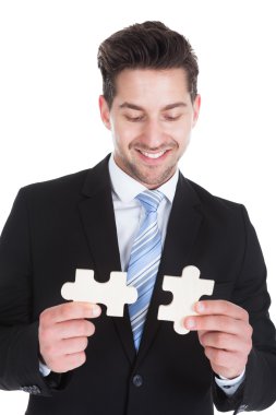 puzzle parçaları tutan işadamı
