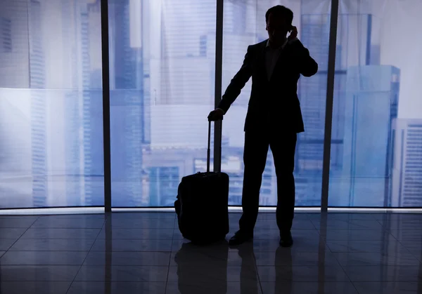 Empresário com bagagem usando telefone celular — Fotografia de Stock