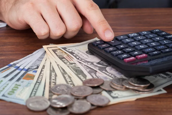 Geschäftsmann benutzt Taschenrechner mit Geld — Stockfoto