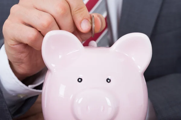 Empresário Inserindo Moeda Em Piggybank — Fotografia de Stock