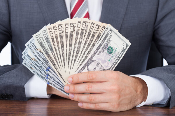 Businessman Holding Fanned Banknotes